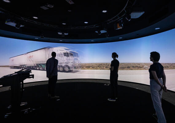Three students stand in front of a large 360 degree screen in the Nyaal precinct at the Geelong Waurn Ponds Campus.