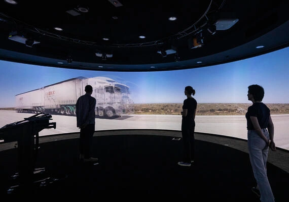 Three students stand in front of a large 360 degree screen in the Nyaal precinct at the Geelong Waurn Ponds Campus.