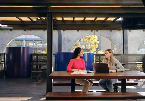Two Deakin students sitting and talking at Geelong Waurn Ponds Campus