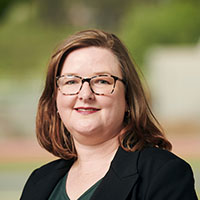 A headshot of Janine Kuster smiling at the camera.