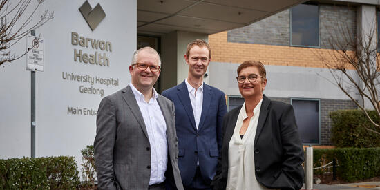 The VC Iain Martin standing with two others in front of Barwon Health.