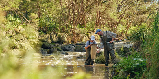 Two researchers conducting environmental management water testing.