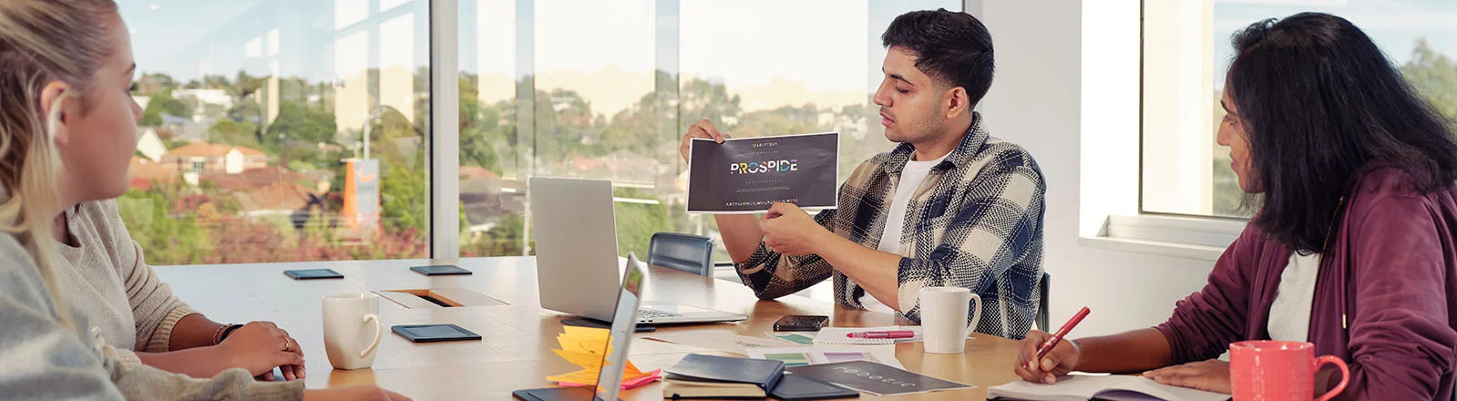 Deakin student sitting on table and discussing a project idea.