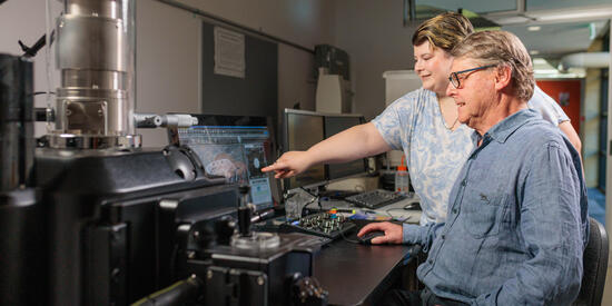 Graduate researcher Nicole Toomey and associate research fellow Asher Winter walking on campus.