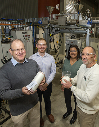 A Deakin researcher and industry partners in a lab