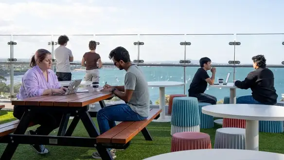 Students sitting on the balcony of Geelong Waterfront accommodsation.