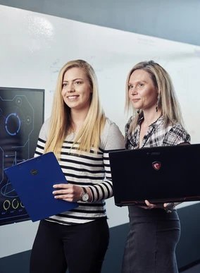 Two Cyber Security students working with computers.