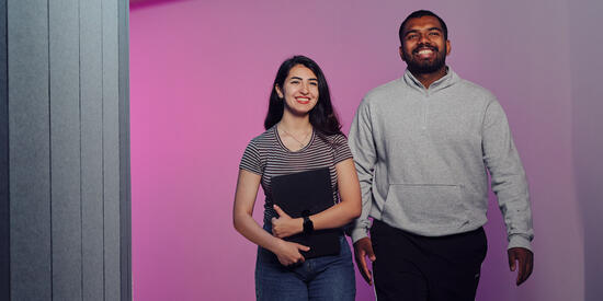 Undergraduate students walk through the IC Building of the Waurn Ponds campus holding laptops and backpacks.