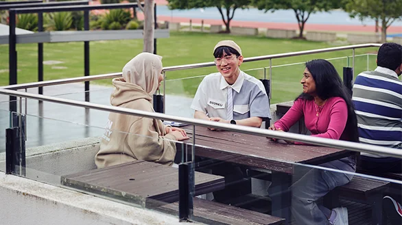 Three Deakin students at a picnic table