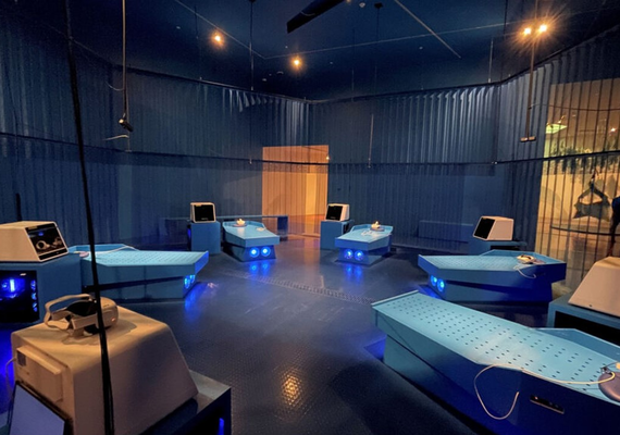 A room set up with computers and recliners for an immersive art experience.