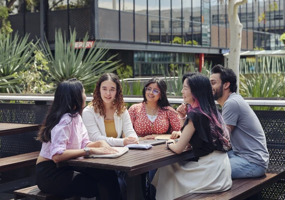 A group of students talking at a cafe on the Geelong Waurn Ponds Campus.
