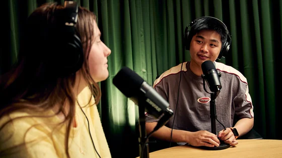 Two students sitting in podcast studio