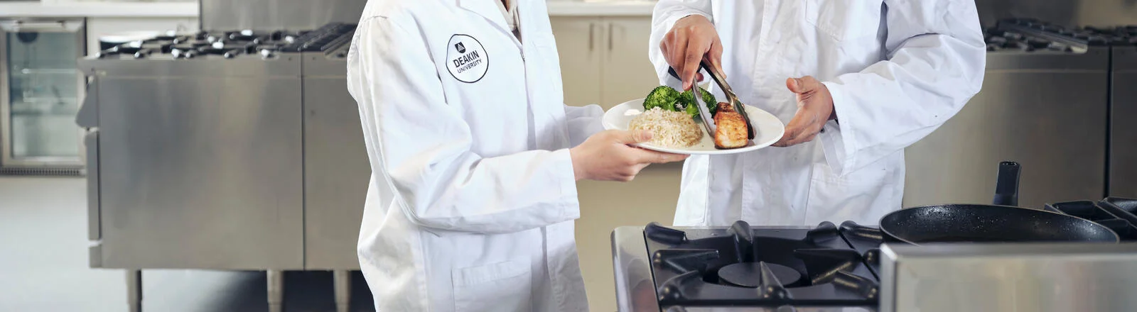 Deakin master of nutrition and population health students in a campus lab studying a plate of food.