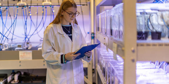 Deakin Marine biology student standing in lab in a coat.
