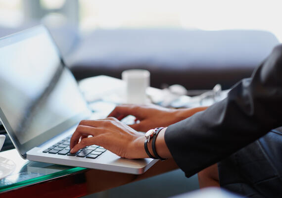 Hands typing on laptop computer.