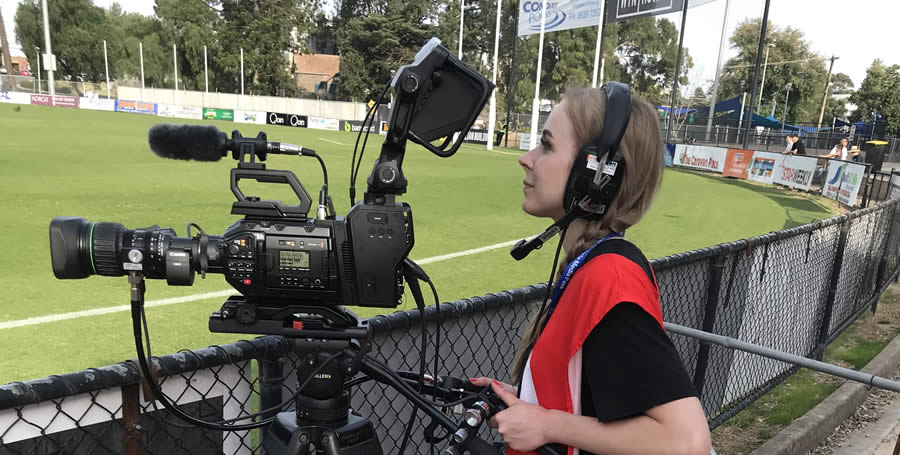 A Deakin student camera operator filming VFL at Victoria Park.