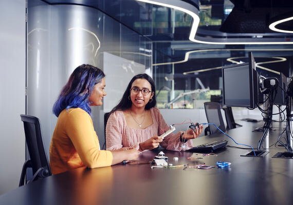 Two IT students collaborating at desk