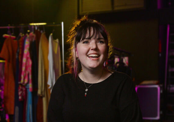 Communications student Isobel Brownbill sitting on a stool on set.