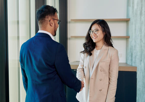 Two Deakin students shake hands.