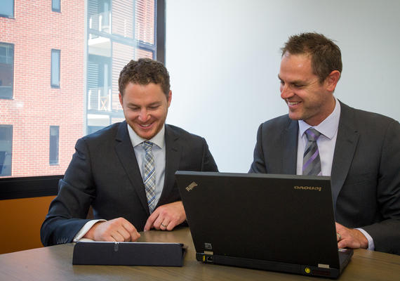 Two business people at a desk with a laptop.
