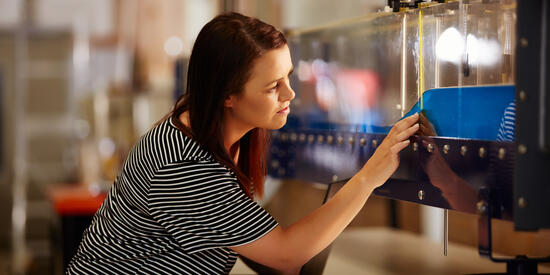 Civil engineering student checks measurements on a wave tank.