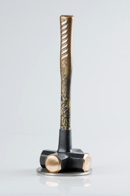 Brass and gold sculpture of four pronged hammer