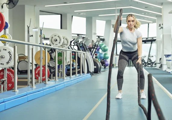 An athlete using the battle ropes at the gym.