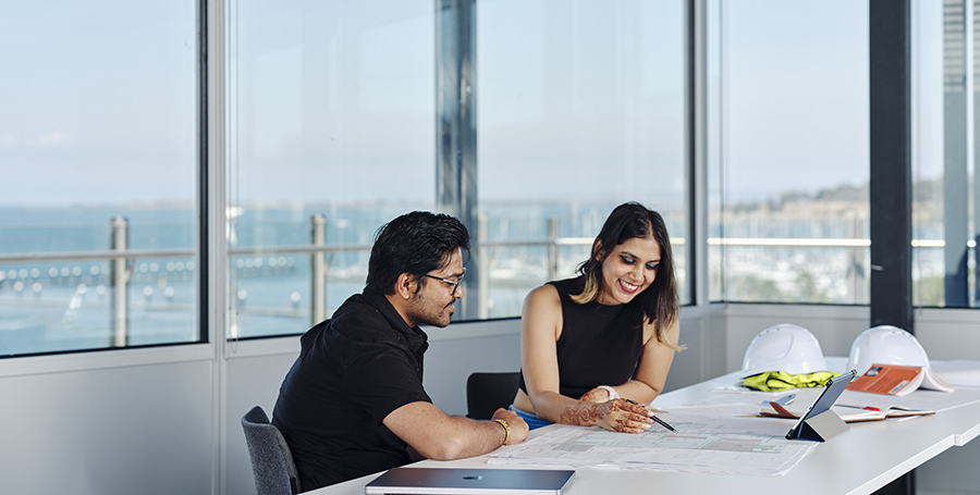 Two students working on designs at a table
