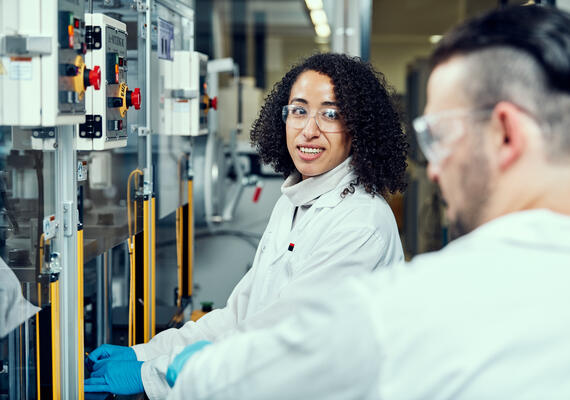 Researchers stands in front of a machine at Deakin Waurn Ponds Campus BatriHub.
