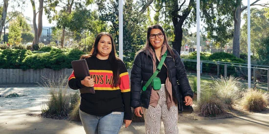 Two Deakin students walk together outside the NIKERI Institute, Deakin University. 