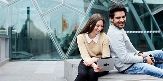 Two students laughing together outside