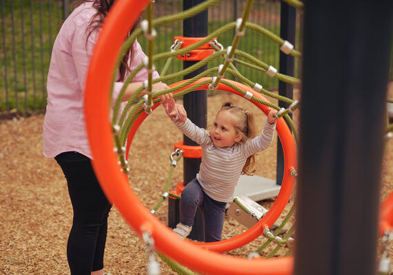 Small female child on climbing equipment at a park