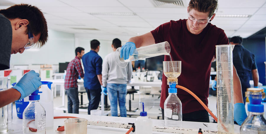 Student pouring solution into funnel