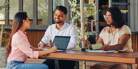 Three Deakin postgraduate students having a meeting.
