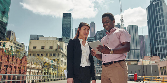 Two students in the city, looking at a document