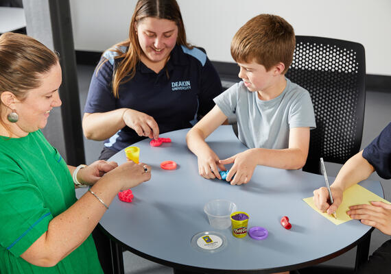 Occupational therapy students working with a young child at a table at the Waterfront Campus.