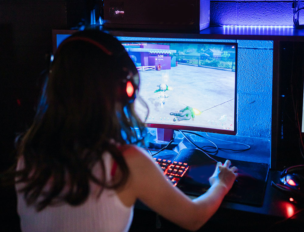 A person wearing headphones, playing a violent online game