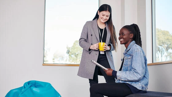 Two Deakin master of social work students work and talk together on campus.