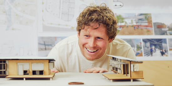 Architecture partner admiring a model house at Deakin's Geelong Waterfront Campus.