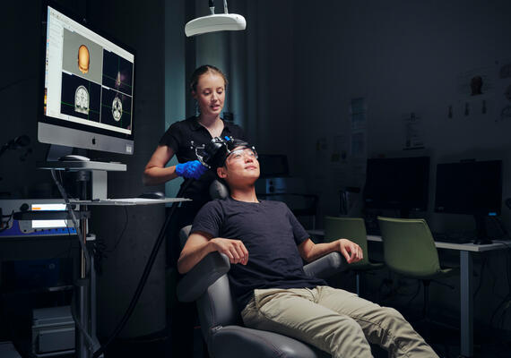 Two people using a transcranial magnetic stimulation machine