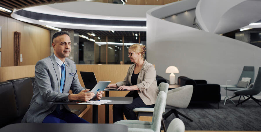 Two Deakin University professionals working in the lounge at Melbourne Downtown Corporate Centre.