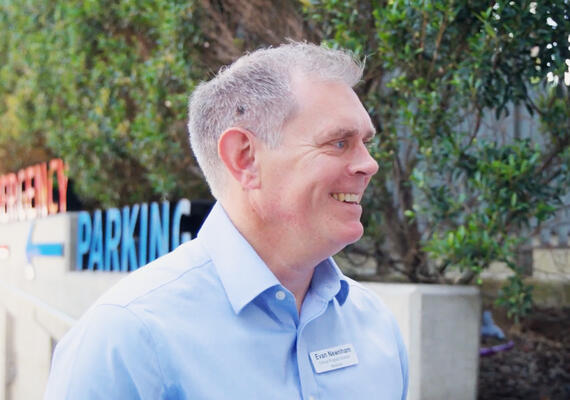 MBA Alum Evan Newnham smiling and talking to a person outside