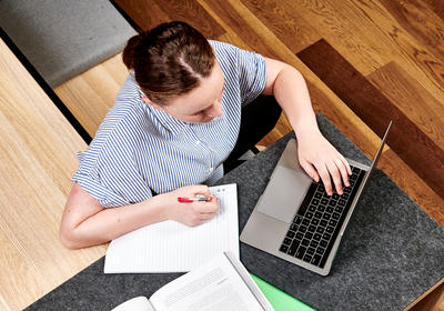 Student sits at table on a laptop