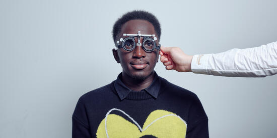 A person holding up an eye instrument in front of a Bachelor of Vision Science/Master of Optometry student at the Waurn Ponds campus.