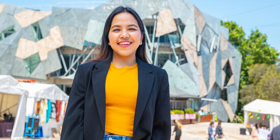 A student standing in front of Fed Square.