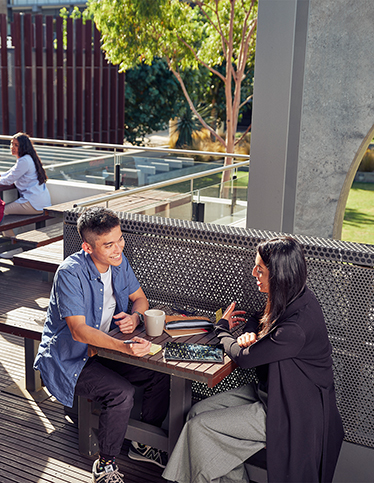 Two Deakin students socialise on Waurn Ponds campus