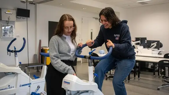 Two students trying the sports equipment at Deakin Open Day.