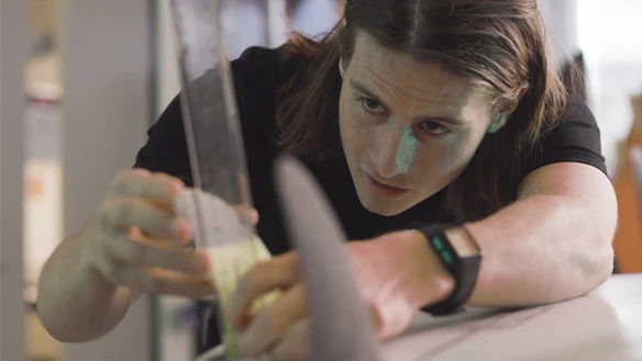 Deakin engineering research student working on a surfboard on campus.