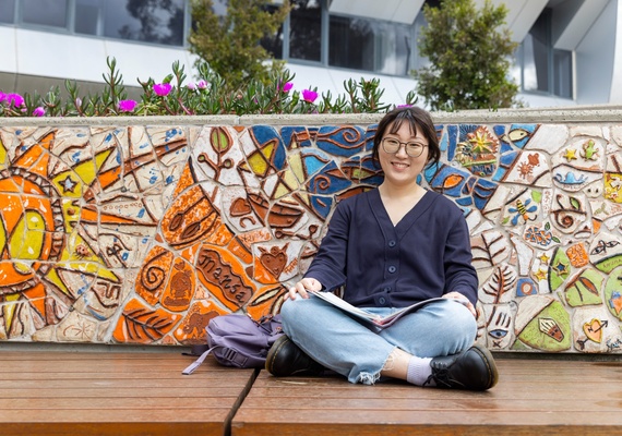 DUELI student from China studying and smiling at the camera