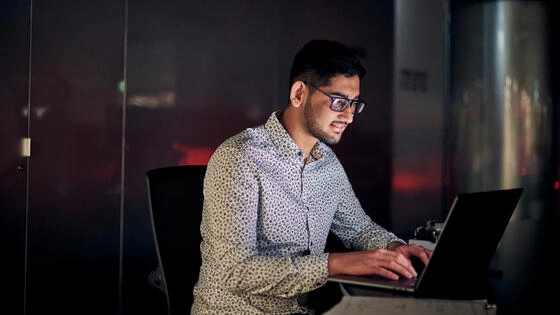 A Deakin master of cyber security student at a computer.